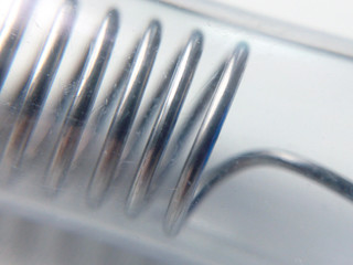 Metal spring in a glass flask Elastic adaptation macro photography