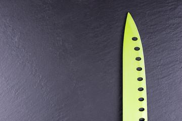 Green kitchen knife on black slate plate