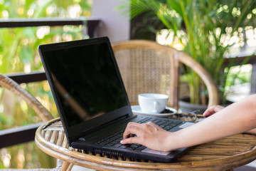 Young woman using laptop computer. Female working on laptop in an outdoor cafe.