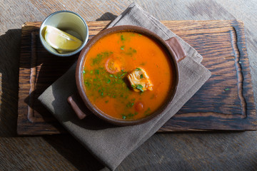 Marmitako soup in a ceramic bowl on a wooden board