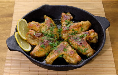 chicken winggs and tosts on a pan and lemon