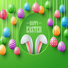 Colorful easter eggs hanging with bunny ears in egg hole on green background