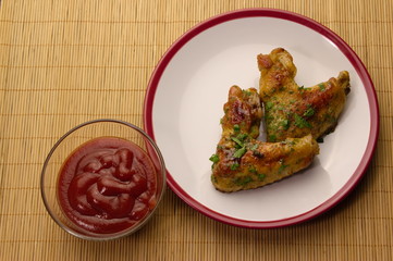 chicken winggs and tosts on a plate and ketchup