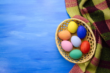 Easter eggs in yello basket on blue and fabric backgrounds S1V15