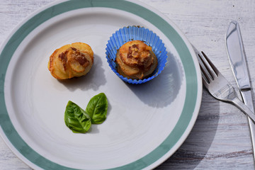 Homemade baked  Potato Muffins with bacon and basil served at white plate 