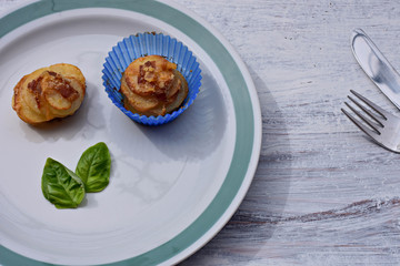Homemade baked  Potato Muffins with bacon and basil served at white plate 