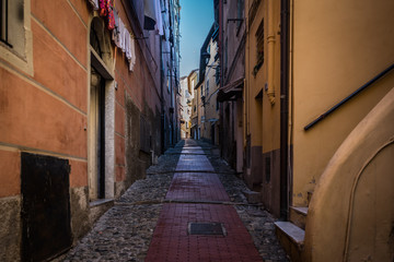 Fototapeta na wymiar The narrow and dark streets of the Italian city of Ventimiglia