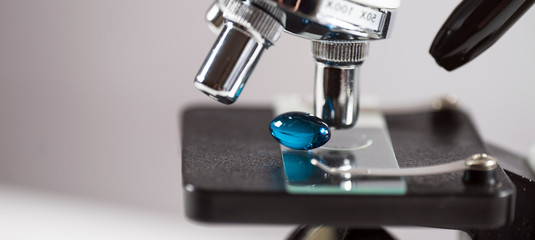 Laboratory Microscope, pills and test tubes. Scientific and healthcare research background.