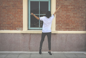 backside of woman jumping with gladness outdoors.