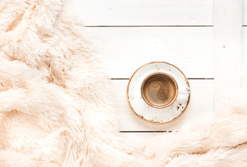 Cup coffee on a wooden table and a warm blanket. Autumn or Winter concept, Flat lay