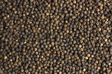 Black peppercorn seeds background. Macro shot