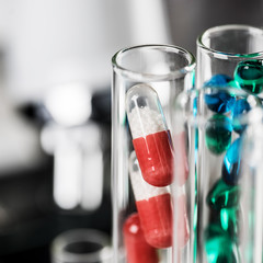 Laboratory Microscope, pills and test tubes. Scientific and healthcare research background.