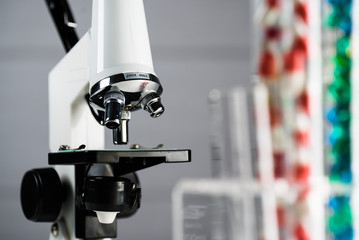 Laboratory Microscope, pills and test tubes. Scientific and healthcare research background.