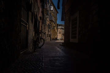 Fototapeta na wymiar The narrow and dark streets of the Italian city of Ventimiglia