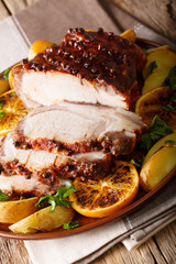 Christmas baked pork with potatoes, oranges and apples. vertical