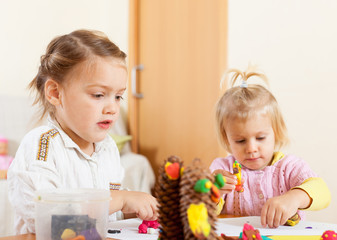 Obraz na płótnie Canvas Preschoolers molding figurines from plasticine .