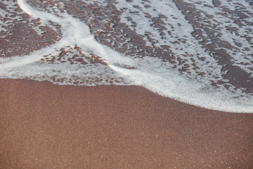 Waves lapping on the black sand