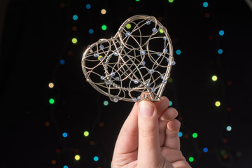 Heart shaped metal cage on bokeh light background