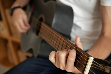 Fototapeta na wymiar Hands of unrecognizable man playing acoustic guitar