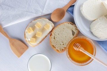 Cheese and honey on a white plate, kefir, a sandwich with soft cheese, minimalism, honey, a piece of bread, blue napkin, French breakfast on a white background, American cuisine
