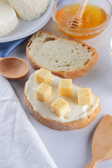 Cheese and honey on a white plate, kefir, a sandwich with soft cheese, minimalism, honey, a piece of bread, blue napkin, French breakfast on a white background, American cuisine