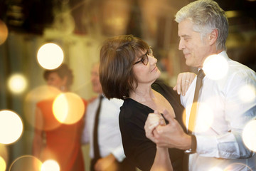 Romantic senior couple dancing together at dance hall