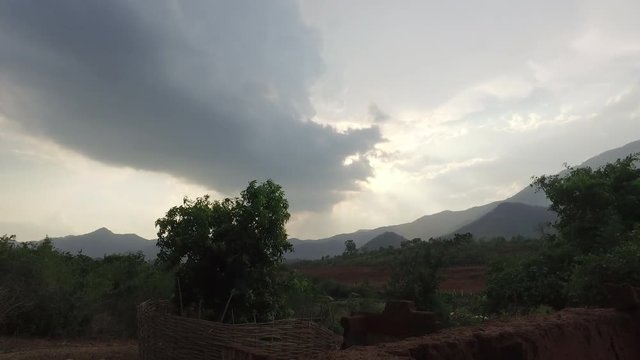 A cinematic time lapse of a windy mountain view, clouds and trees.