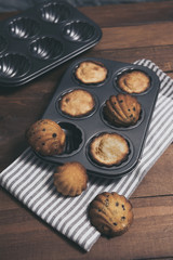 Homemade french madeleines with beurre noisette and chocolate on wooden table. Vertical.