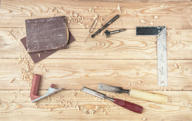 Woodworking and crafts tools. Carpentry hand tools on a workbench. Planers, chisels, measuring tools. square, drill, sandpaper, Wooden parts, planks and stocks. Wooden background with empty spase.