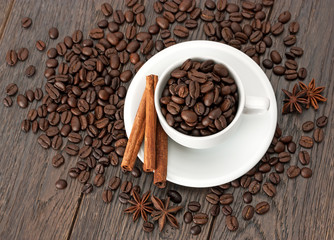 A Cup of coffee and coffee beans on wooden table.