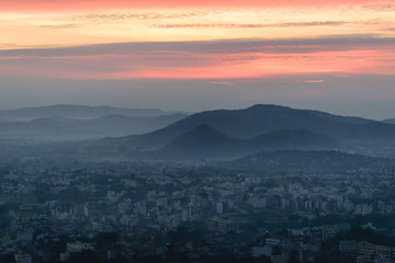 Mountain layers, sunrise and city