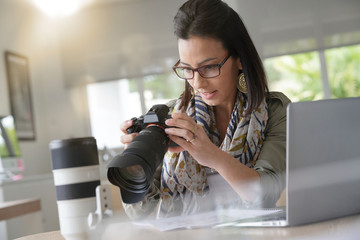 Young woman photographer checking previews on camera