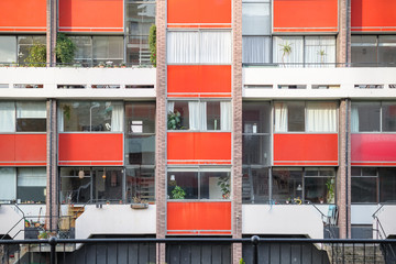 Housing block faced with panels in orange colour at golden lane estate in London