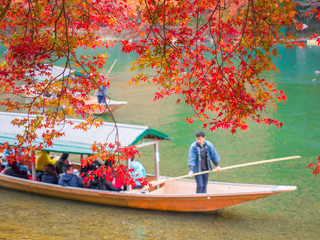 Red maple leaf with tourism in the boat when autumn in Arashiyama, Kyoto.