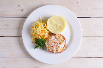 Fish cutlet with ham and melted cheese topping served with pickled cabbage and mashed potato