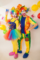 Clowns are a boy and a girl in bright costumes at the child's birthday. The explosion of emotions and the fun of the circus