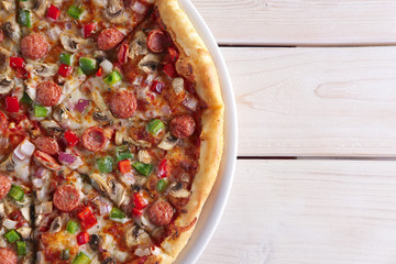 Pizza with sausage, ham, tomato, zucchini and paprika