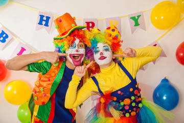Clowns are a boy and a girl in bright costumes at the child's birthday. The explosion of emotions and the fun of the circus