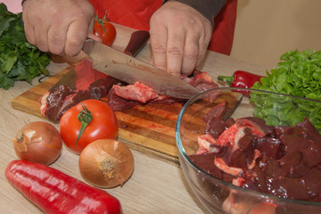 Butcher cutting meat on kitchen. Man in the kitchen cutting a piece of meat