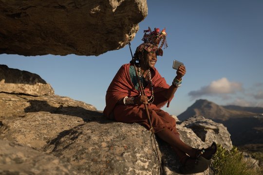 Maasai man in traditional clothing using mobile phone