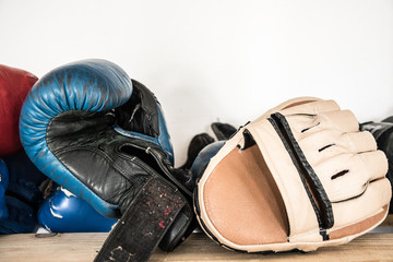Set of worn boxing and kickboxing accessories: gloves, focus punch pad
