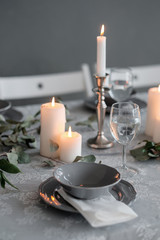 Wedding or festive table setting. Plates, wine glasses, candles and cutlery