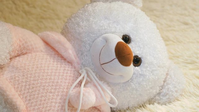 Soft beautiful polar white bear baby toy lying on couch at baby room. Close-up