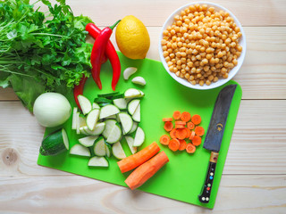 Cooking vegan salad with zucchini and chickpeas. Wooden table. Top view
