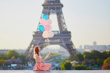 Girl with bunch of balloons in front of the Eiffel tower in Paris