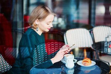 Young elegant woman drinking coffee in cafe in Paris, France