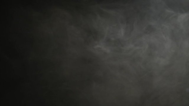 Smoke billowing over a black background