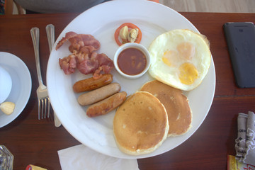 an eggs, sausages, bacon and sauce for breakfast