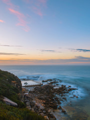 North Curl Curl rock pool view from a distance at sunrise time.