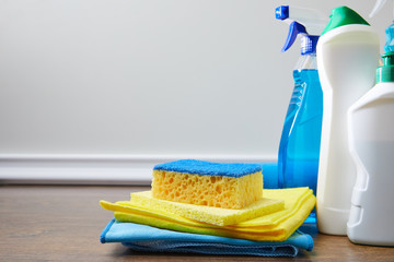 blue and yellow sponge, rags and bottles for spring cleaning